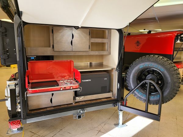 Back of an Adventure camping trailer outfitted with collapsible grill at Earthship Overland at their showroom in Englewood, CO